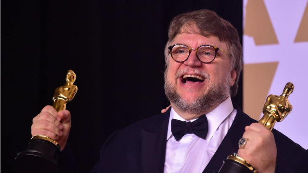 Guillermo del Toro hoists his two awards for The Shape of Water at the 2018 Oscars. [© Photo AFP, Frederic J. Brown]